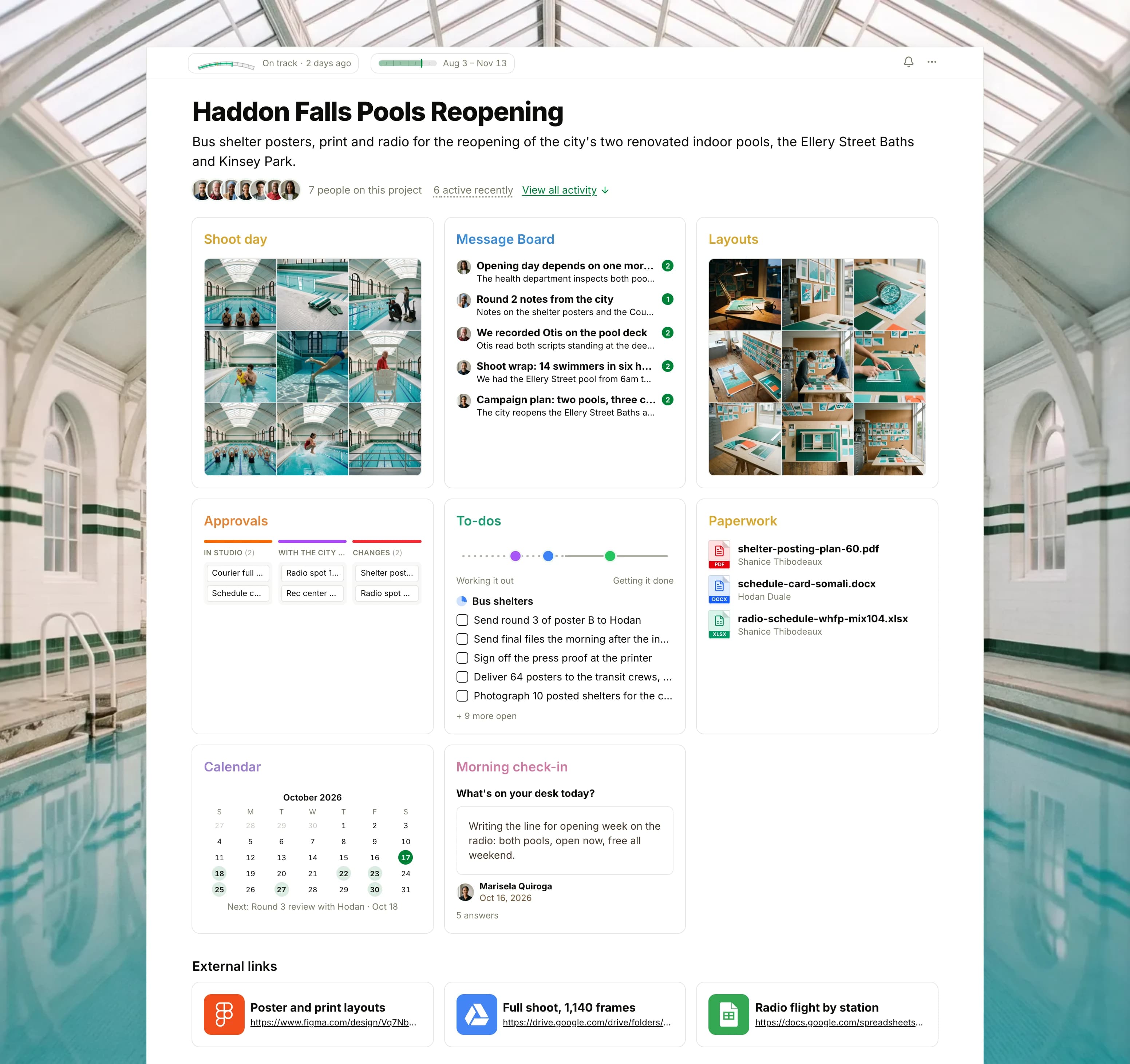 The Haddon Falls Pools Reopening project in Thicket over a photograph of an empty 1920s indoor pool hall: the health flag reading On track, the campaign dates and seven people, then eight cards: Shoot day as nine photographs of swimmers at the Ellery Street Baths, the Message Board with the pool inspection on top, Layouts as nine photographs of the studio's prints and poster proofs, the Approvals board with cards in In studio, With the city, Changes and Approved, To-dos with three lists on the progress chart, Paperwork with the shelter posting plan, the Somali schedule card and the radio schedule, the Calendar with the inspection, the posting days and opening day, and the Morning check-in, then External links to the layouts, the full shoot and the radio flight.
