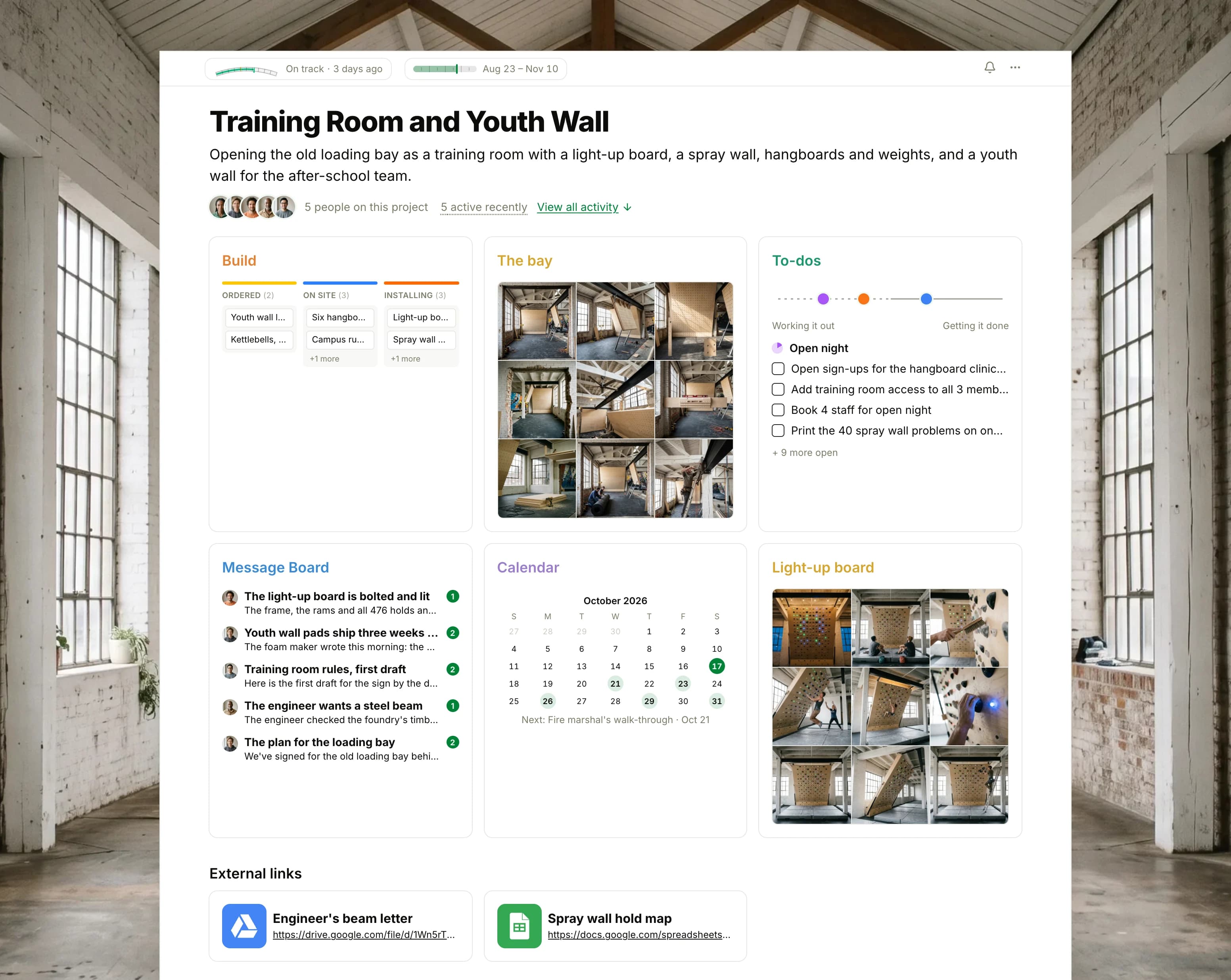 The Training Room and Youth Wall project in Thicket over a photograph of tall factory windows in a whitewashed brick foundry: the health flag reading On track, the project dates, five people and two links, then six cards: the Build board with cards in Requests, Ordered, On site and Installing, The bay as nine photographs of the training room being built, To-dos with three lists on the progress chart, the Message Board with the light-up board bolted and lit on top, the Calendar with the fire marshal's walk-through next, and Light-up board as nine photographs of the new climbing board being set and tested.