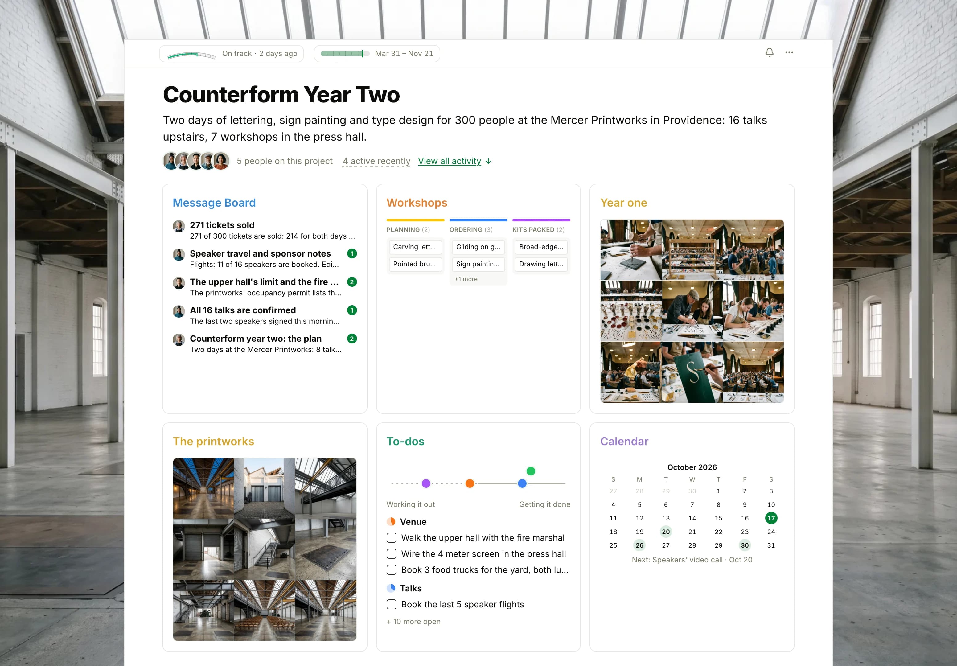 The Counterform Year Two project in Thicket over a photograph of an empty printworks hall under a sawtooth roof: the health flag reading On track, the conference dates and five people, then six cards: the Message Board with this week's ticket count on top, the Workshops board with cards in Planning, Ordering and Kits packed, Year one as nine photographs from the first conference, The printworks as nine photographs from the venue visit, To-dos with four lists on the progress chart, and the Calendar with the speakers' call next.