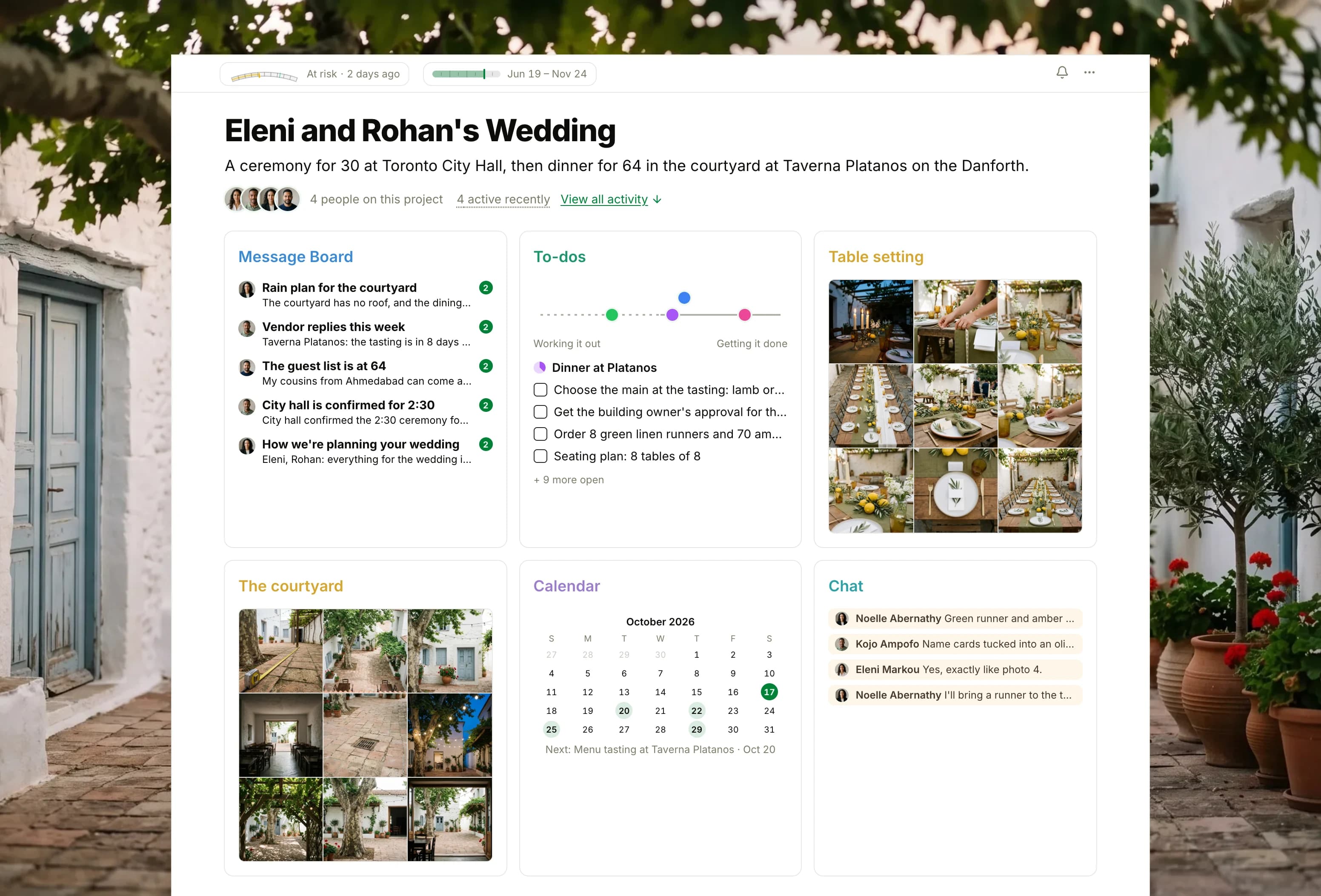 The project for Eleni and Rohan's wedding in Thicket over a photograph of a whitewashed courtyard under a plane tree and a grapevine: the health flag reading At risk, the planning dates and four people, then six cards: the Message Board with the rain plan on top, To-dos with four lists on the progress chart, Table setting as nine photographs of the mock-up dinner table, The courtyard as nine photographs of the taverna's courtyard, the Calendar with the menu tasting next, and Chat between the planners and the couple about the green runner and the amber glasses.