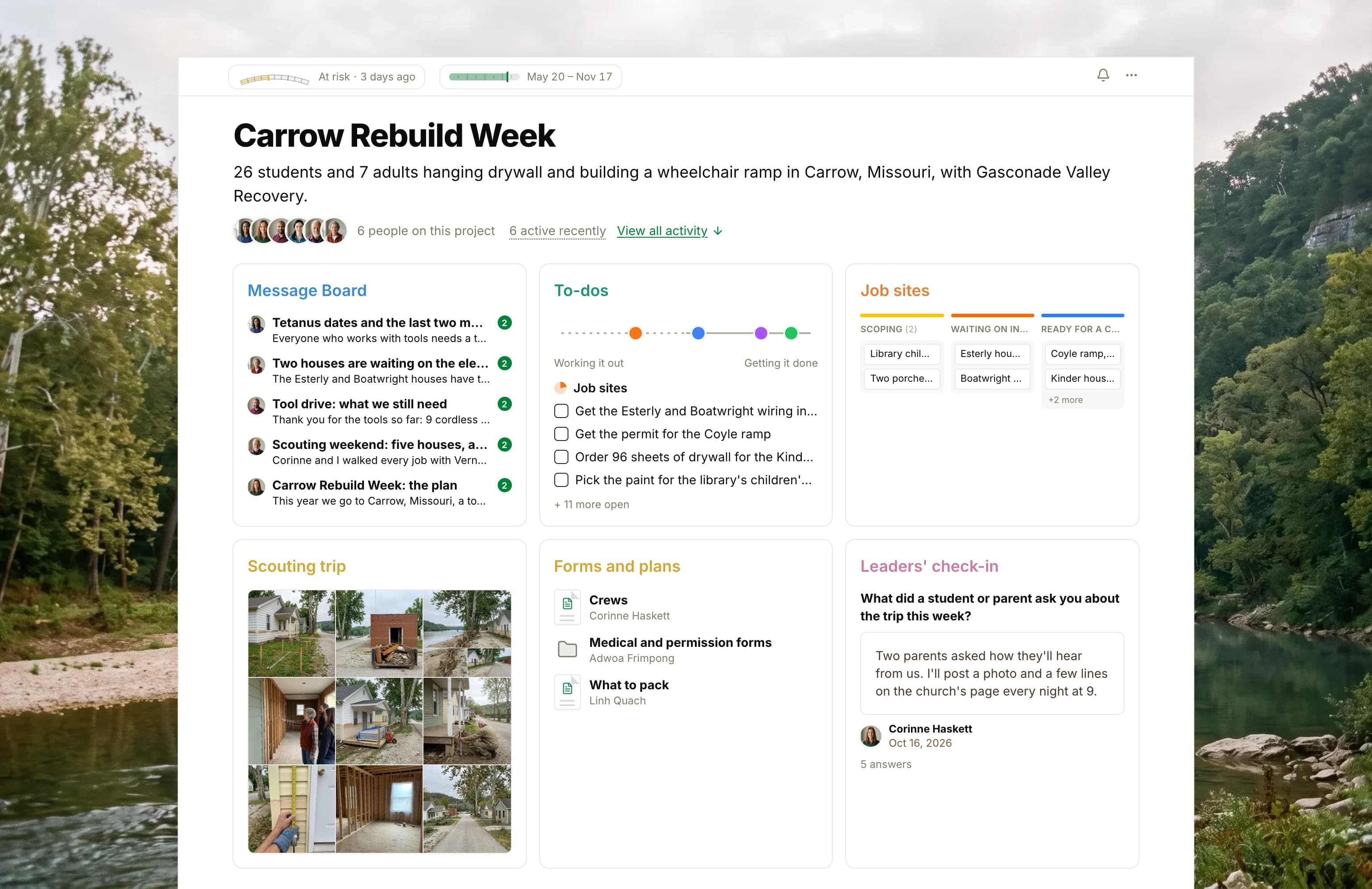 The Carrow Rebuild Week project in Thicket over a photograph of a river valley at dawn: the health flag reading At risk, the trip's dates and six people, then six cards: the Message Board with the tetanus dates on top, To-dos with four lists on the progress chart, the Job sites board with cards in Scoping, Waiting on inspection and Ready for a crew, Scouting trip as nine photographs of the flooded town and its houses, Forms and plans with the crews, the medical forms and the packing list, and the Leaders' check-in with this week's answers.